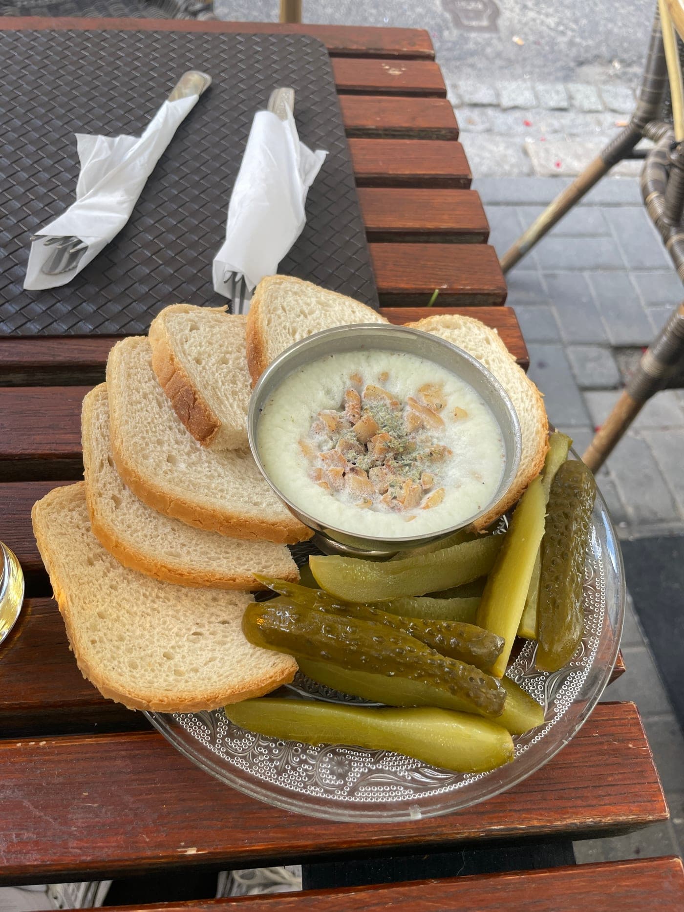 Fresh bread with smalec and pickled cucumbers on a Warsaw café table