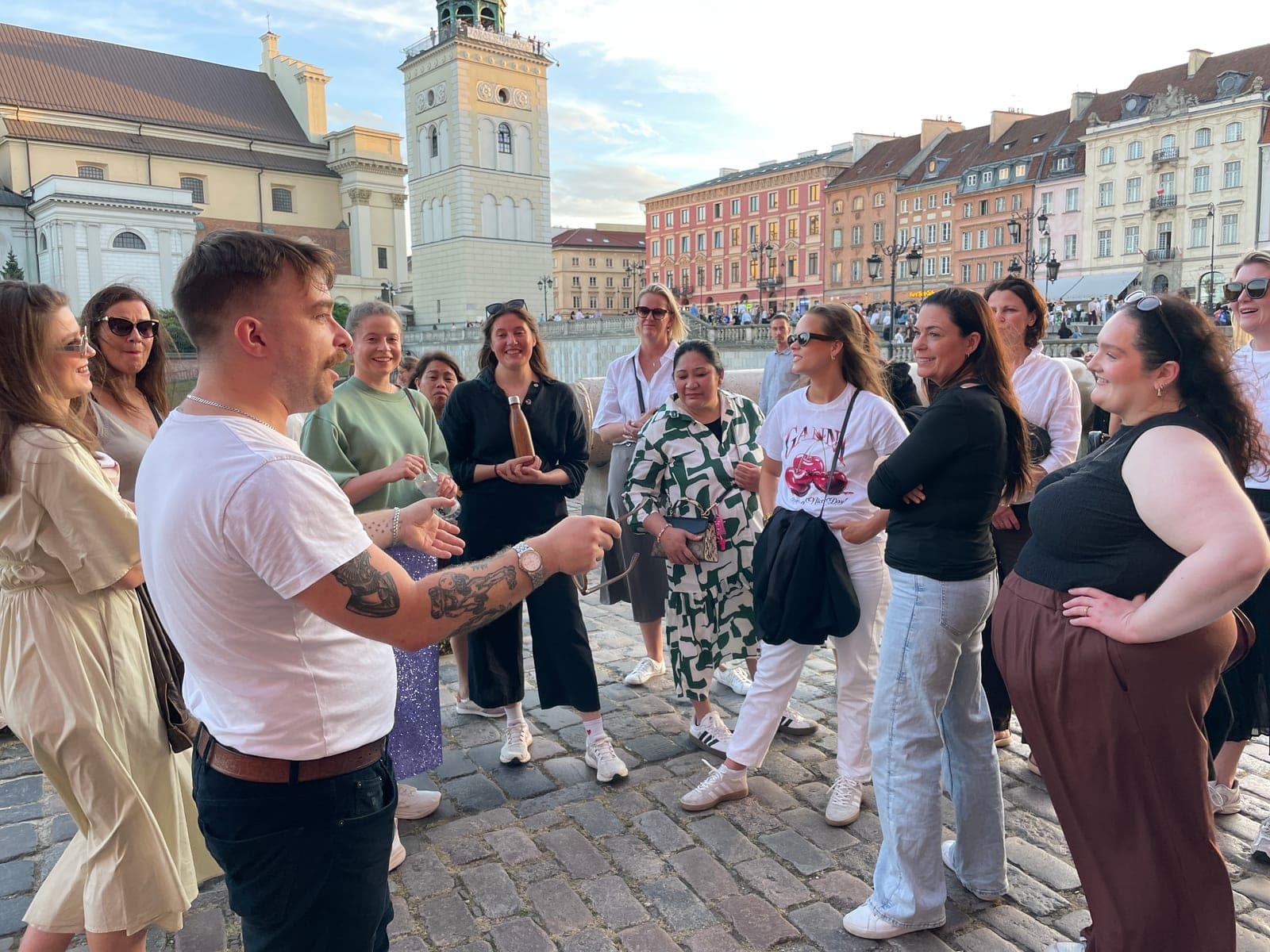 Tasty Trails guide telling stories to a tour group on Castle Square in Warsaw's Old Town