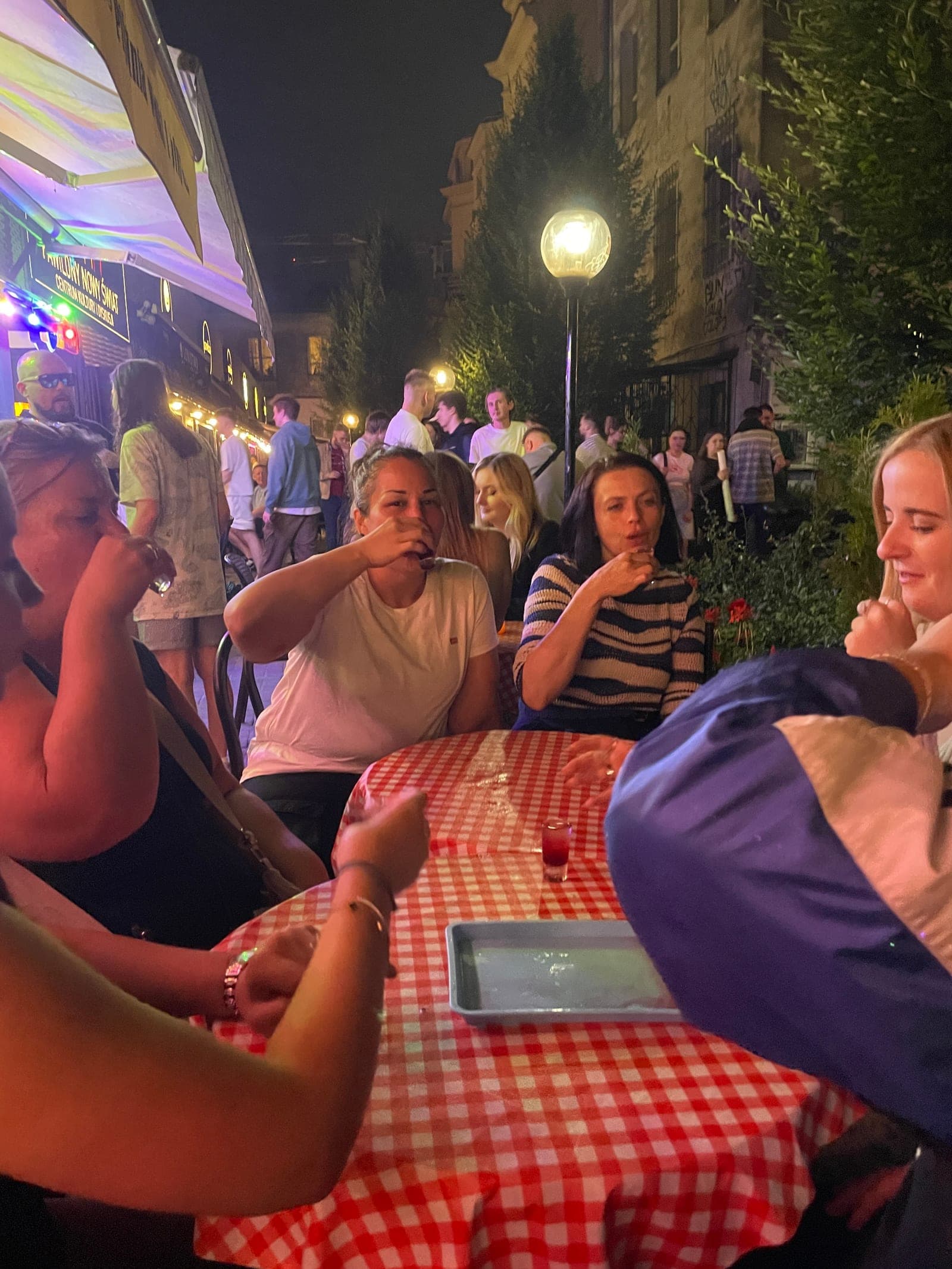 Evening tour group at a candlelit Warsaw outdoor table